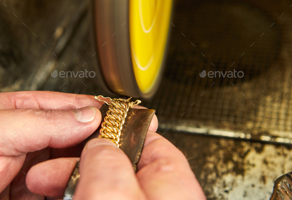 Jewelry production. Jeweler polishes a gold bracelet