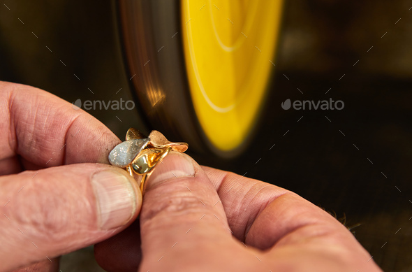 Jewelry production. Jeweler polishes a gold ring on a sander