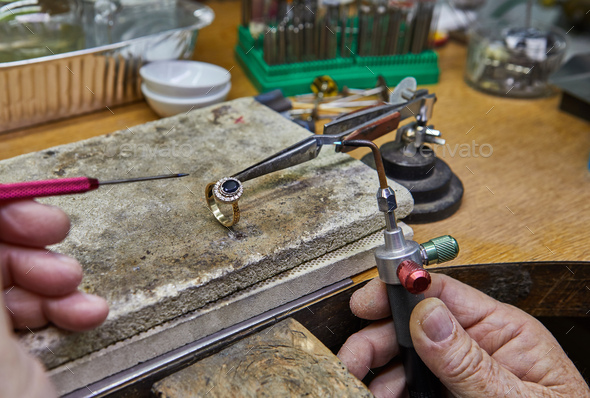 Jewelry production. The jeweler makes a gold ring.