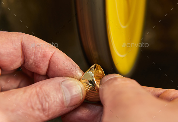 Jewelry production. Jeweler polishes a gold ring on a sander