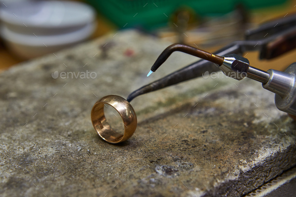 Jewelry production. The jeweler makes a gold ring.