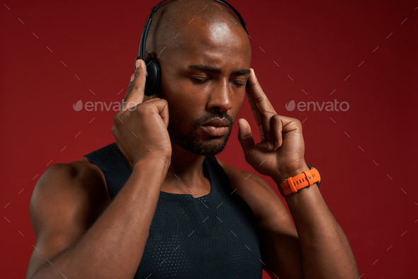 Music is my motivation. Portrait of handsome afro american man in headphones keeping eyes closed
