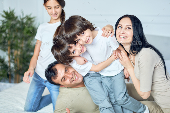 Home is where the family is. Close up portrait of happy latin family, parents and children smiling