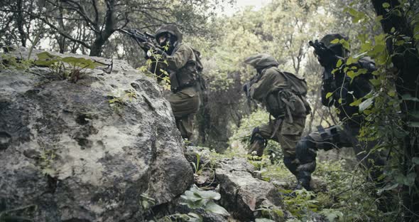 Squad of fully armed commando soldiers during combat in a forest ...