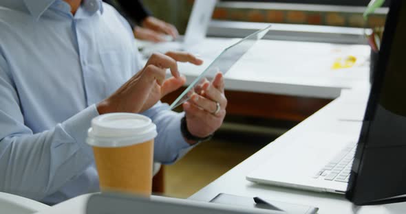 Executive using glass digital tablet in office 4k alt