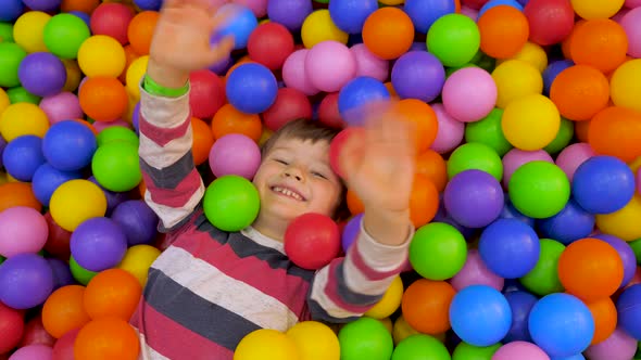 Entertainment concept. Happiness in bright colors. Smiling boy waving hello at entertainment center
