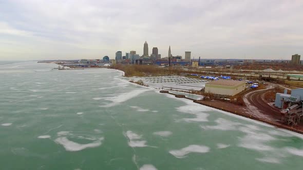 Wide revealing drone shot of downtown Cleveland Ohio and a frozen Lake Erie alt