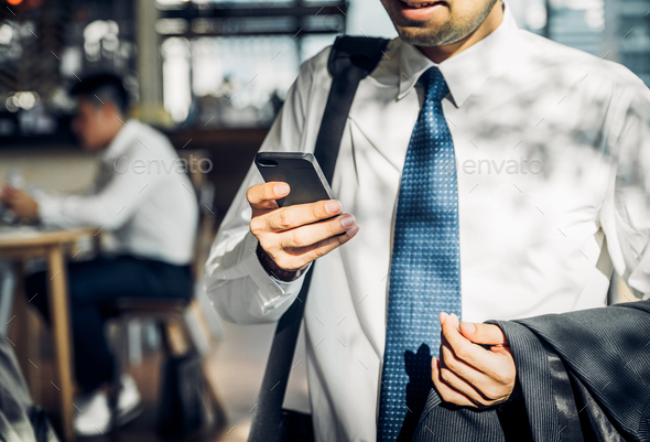 Businessman using mobile phone to chatting with friend after work