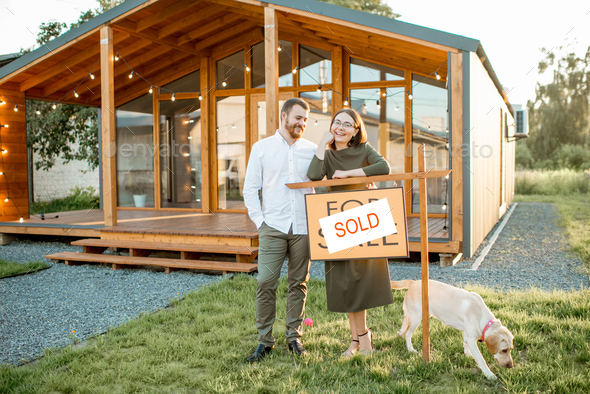 Couple in front of their new house - Stock Photo - Images