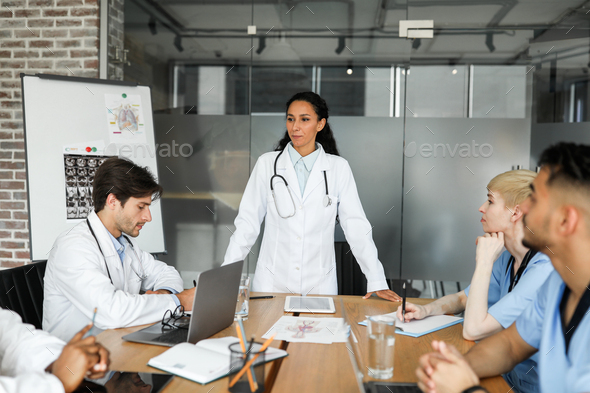 Brunette woman chief physician making presentation in front of colleagues