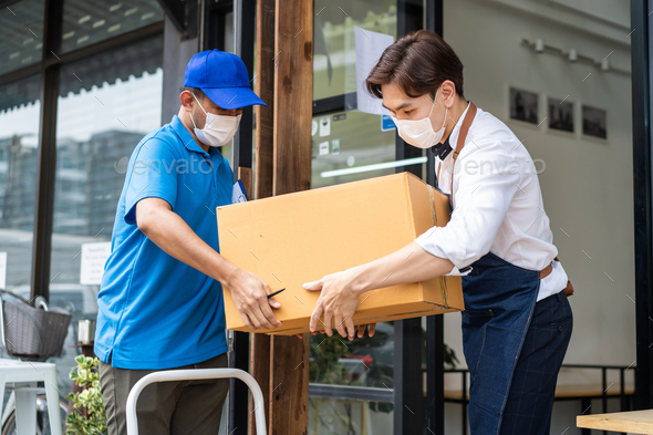 Asian Postman deliver food ingredient box to restaurant waiter in cafe.