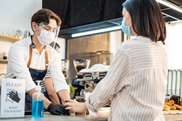 Asian Woman customer wear mask due to Covid-19 pandemic, receive drink from waiter on coffee bar