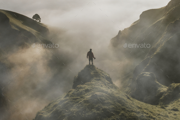 Man standing on cliff with fog overlay texture