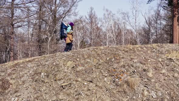 Active Young Mother Hiking with Her Two Sons on a Forest Trail alt