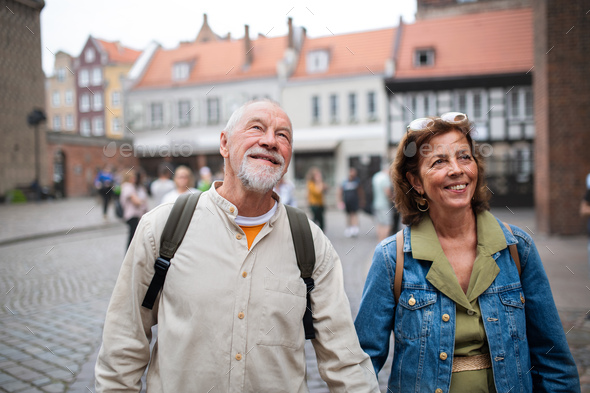 Portrait of happy senior couple tourists outdoors in historic town - Stock Photo - Images