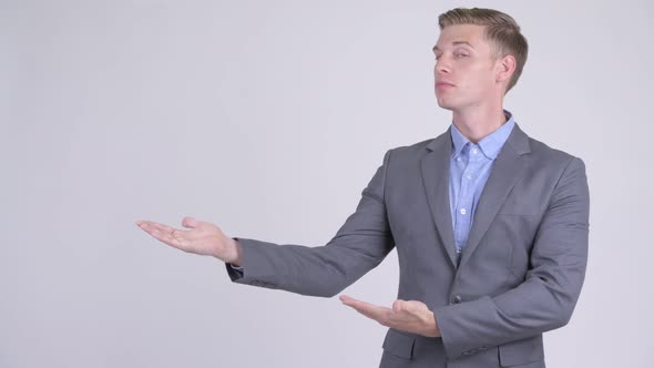 Happy Young Handsome Businessman Showing Something alt