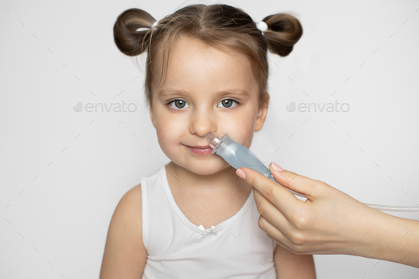 Close up of mother hand using nose vacuum cleaner sucking out nasal mucus from nose of cute adorable