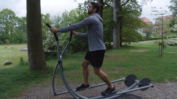 Athlete Using Forest Cross Trainer Gym Equipment
