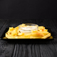 Fried French fries on a plate with sauce on a black wooden background. - PhotoDune Item for Sale