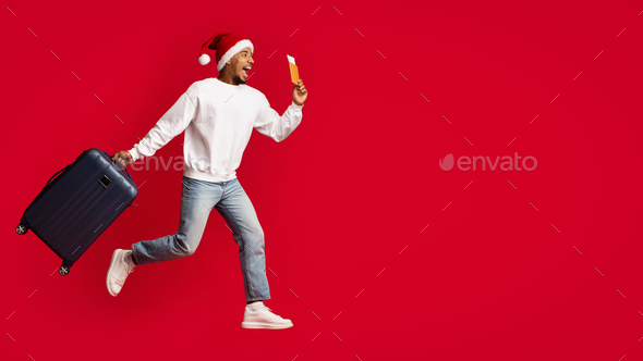 Emotional black guy in Santa hat holding suitcase and passport