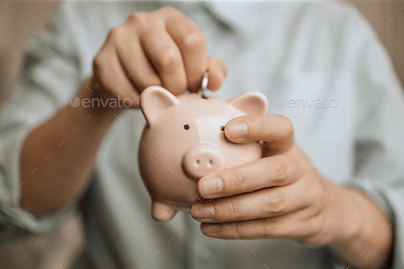 female hands hold a pink piggy bank and coin puts. Save money and financial investment - Stock Photo - Images