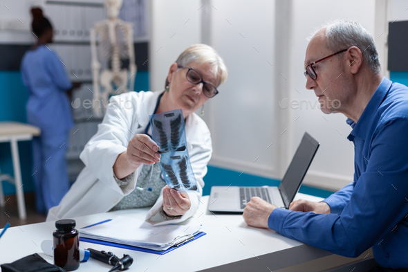 Medic and patient analyzing x ray scan exam results at consultation appointment