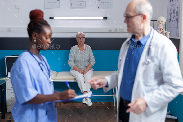 Old person sitting on bed in medical office, waiting to receive assistance and support