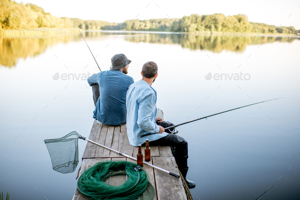 Two men fishing on the lake Stock Photo by RossHelen