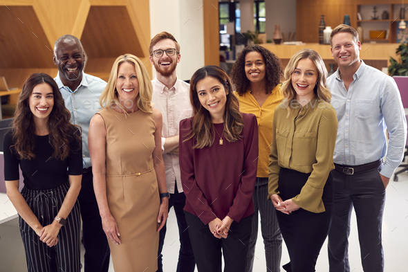 Portrait Of Smiling Multi-Cultural Business Team Standing In Modern ...