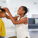 Lovely black mother measuring daughter height against wall at home - PhotoDune Item for Sale
