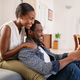 Mature african man and beautiful woman watching movie on digital tablet - PhotoDune Item for Sale