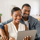 Happy mature african american couple using digital tablet at home - PhotoDune Item for Sale