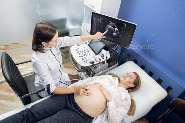 Young professional female ultrasound technician, obstetrician doctor
