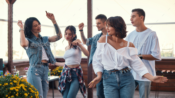 Let\'s dance Group of happy friends enjoying party on rooftop terrace