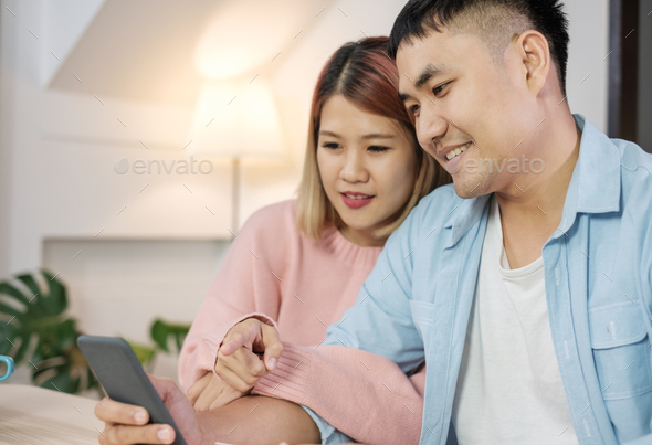 Asian couple use mobile phone shopping online with credit card