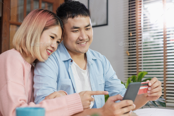 Asian couple use mobile phone shopping online with credit card