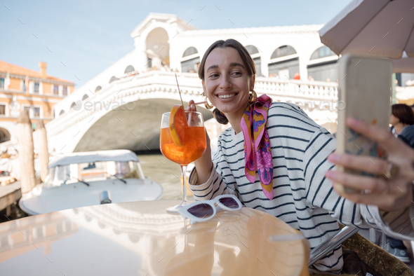 Woman taking selfie at outdoor cafe in Venice, Italy