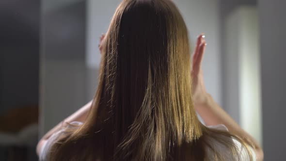 Young Woman Brushes and Touching Her Hair