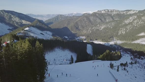 Many Skiers Ride the Ski Slope. Aerial View