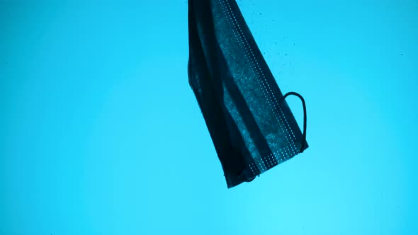Discarded Face Mask Slowly Drifting in Blue Deep of Water Column alt