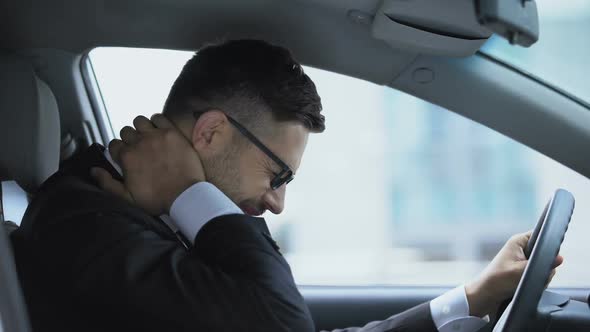 Business Driver Massaging Numb Neck Sitting on Driver Seat, Sedentary Lifestyle