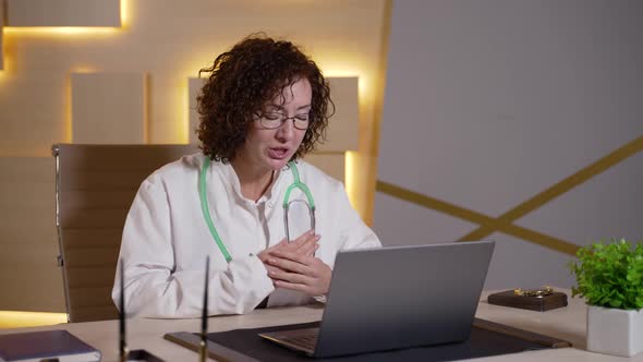 Female Doctor Consulting Patient Online at Laptop alt