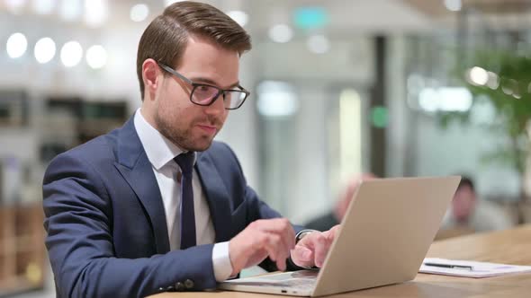 Positive Businessman with Laptop Showing Thumbs Up alt