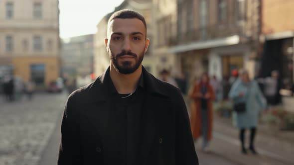 Bearded Arabian Man in Black Formal Wear Walking on Street alt