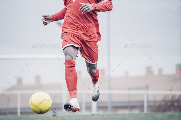 African soccer player with red outfit playing soccer. - Stock Photo - Images