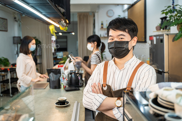 Portrait of Asian waiter worker wear mask, stand with confidence at coffee shop restaurant