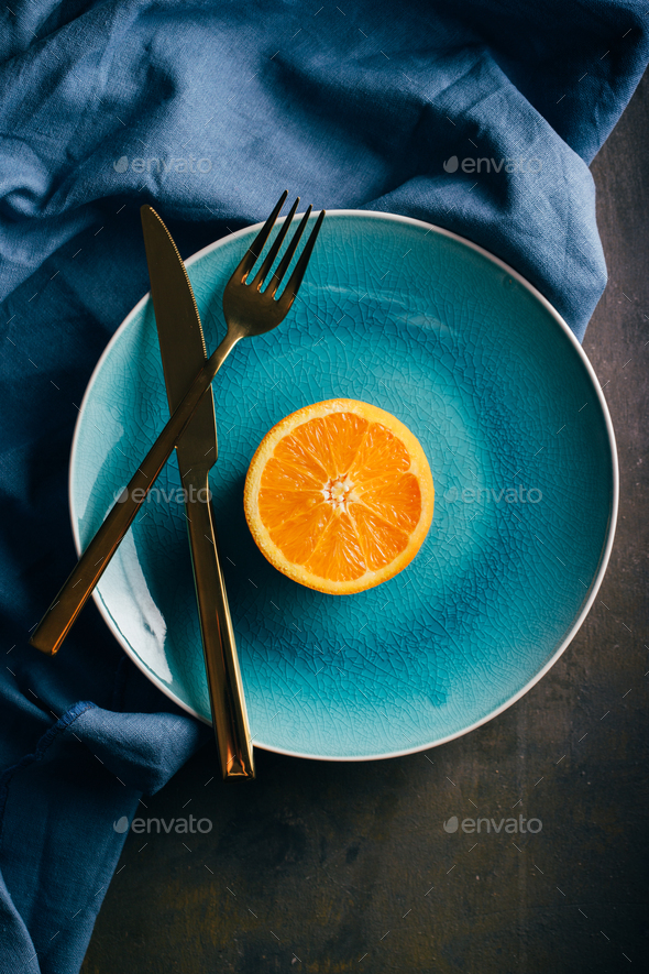 Fresh orange in a teal plate