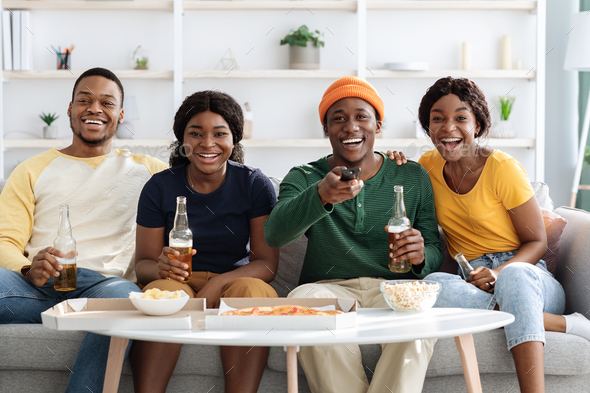Happy african american friends watching comedy on TV - Stock Photo - Images