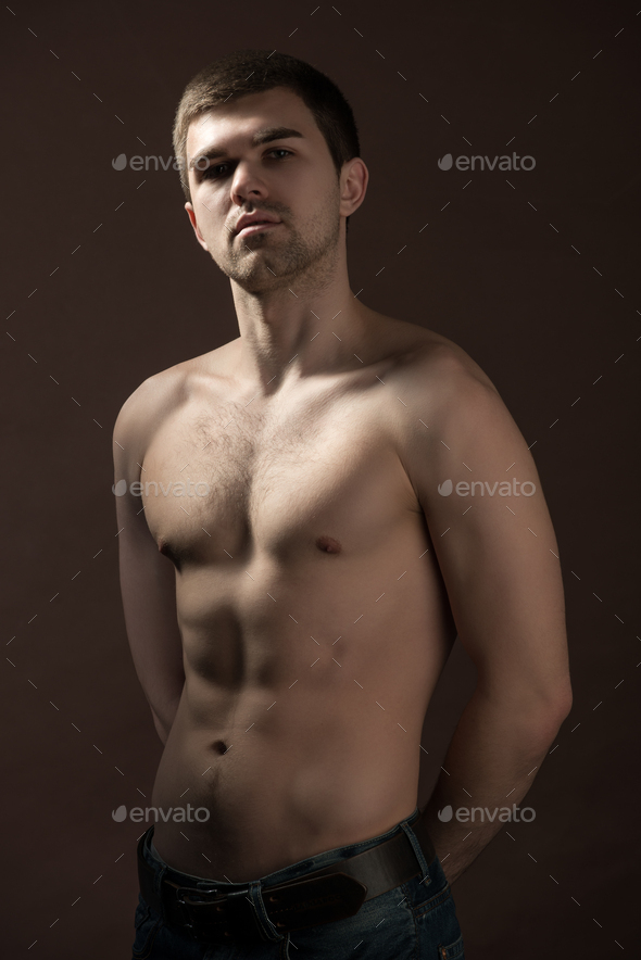 Young man model in brown underpants standing and showing his body