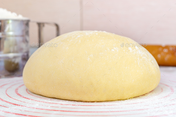 Raw yeast dough on a special silicone baking mat for rolling dough on the kitchen table - Stock Photo - Images